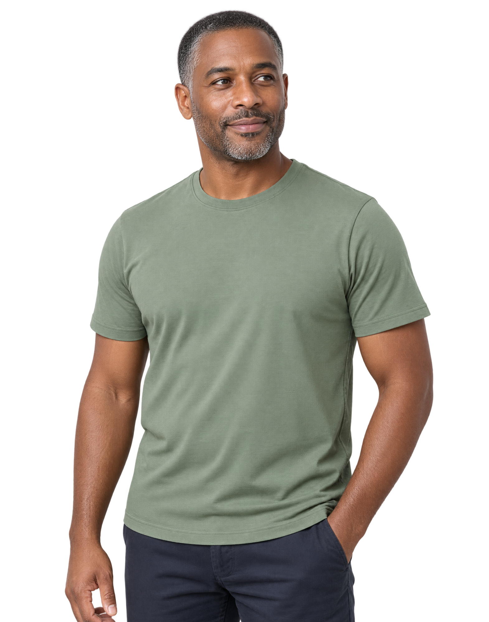A man in a sage-green t-shirt, one hand in his pocket, looking calmly to one side