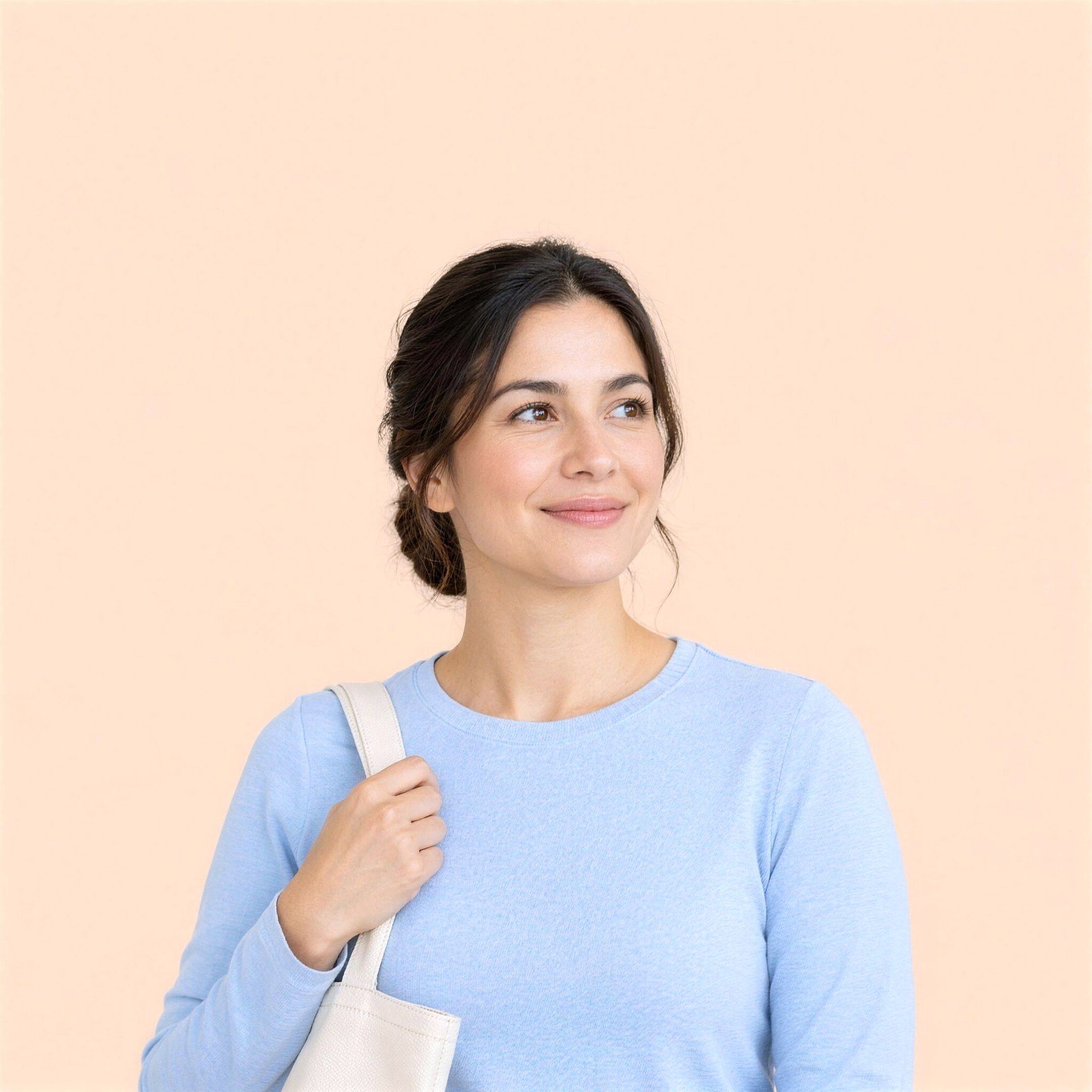 A woman in a pale blue top smiling and looking to one side