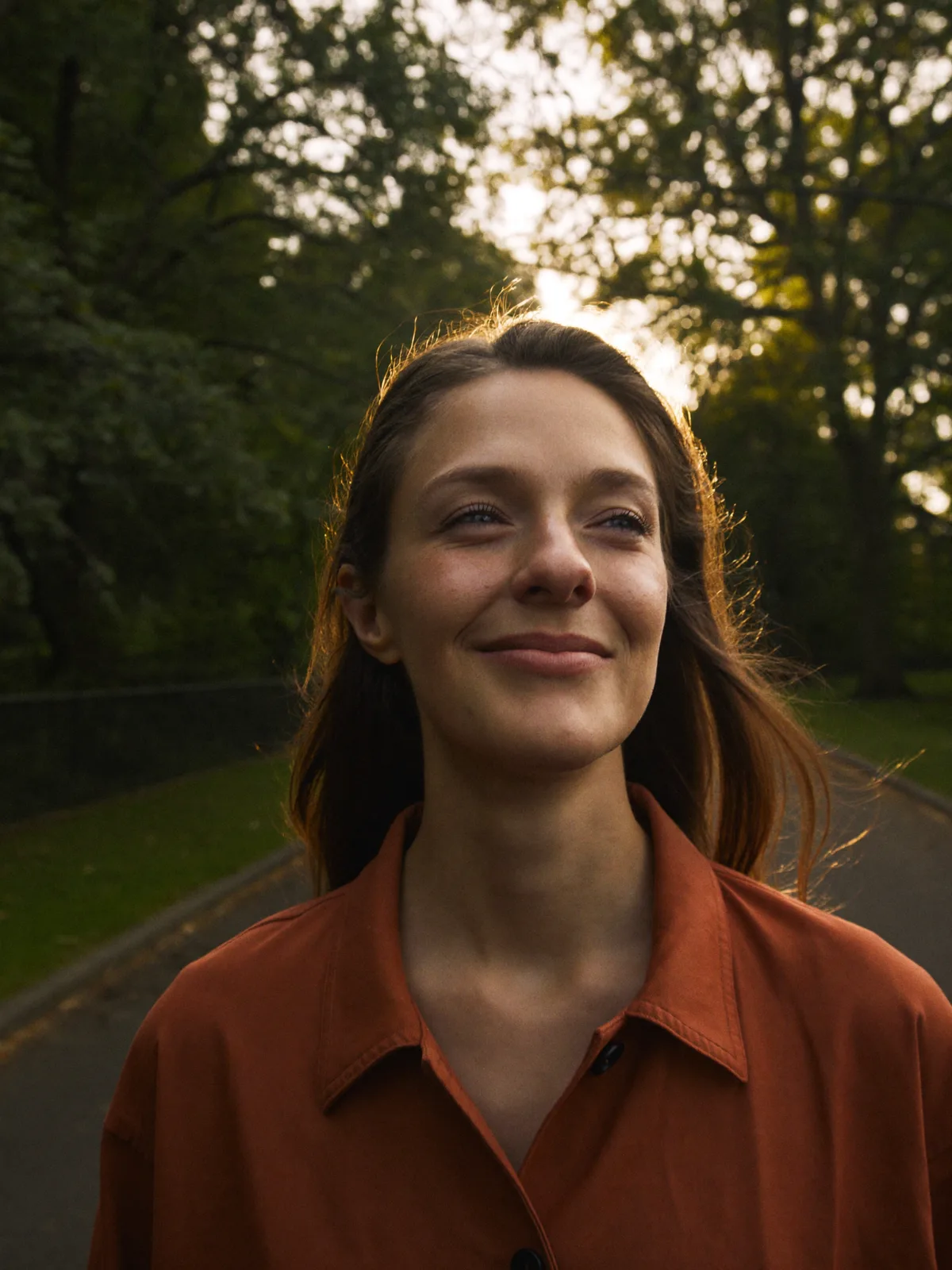 A woman on an unhurried evening walk in the park at golden hour
